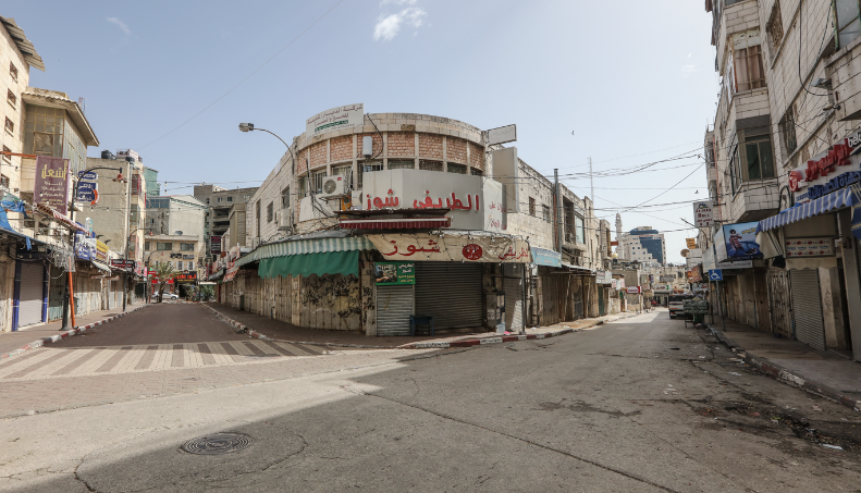 רחובות ריקים ובתי עסק סגורים בעקבות הצעדים האחרונים עליהם הכריז ראש הממשלה הפלסטיני מימין : מרכז העיר ראמאללה (ופא, 23 במרץ 2020). משמאל : מרכז העיר חברון (חשבון הטוויטר PALINFO, 23 במרץ 2020)