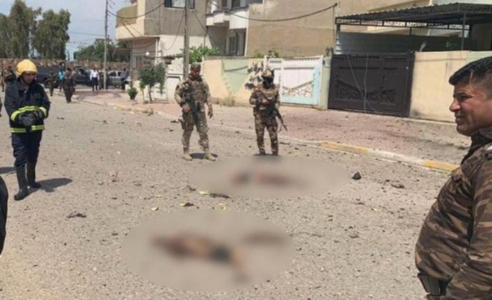 Iraqi security personnel standing near body parts of the suicide bomber (blurred in the original), close to the entrance to the building of the Intelligence and Counterterrorism Directorate in Kirkuk (azzaman@azzamannews, Twitter account of an international Arab daily operating from Iraq, April 28, 2020).