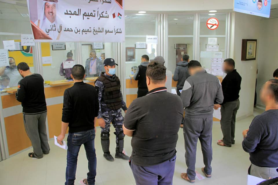 Funds from Qatar distributed at post office bank branches, while people practice social distancing and operatives of Hamas' security forces supervise (Facebook page of Qatar's National Committee for the Reconstruction of Gaza, May 2, 2020).