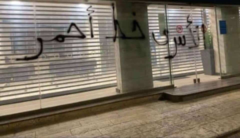 Graffiti sprayed on the front windows of the Arab Bank in al-Bireh. The Arabic reads, "The prisoners are a red line" (Facebook page of RamallahMix, September 19, 2020).