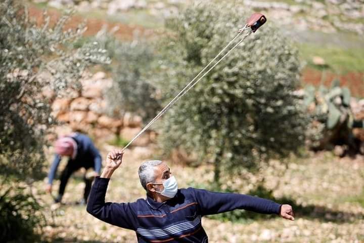 שיח' עאטף חנאישה מיידה אבן במהלך עימותים עם כוחות צה