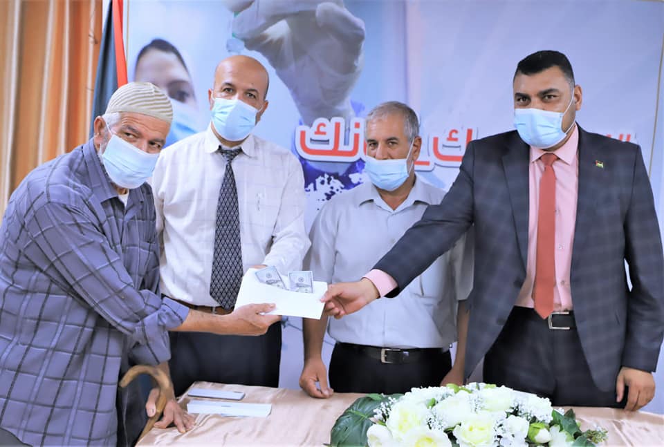 The ministry of health in Gaza gives $200 to local residents who won the vaccination lottery (ministry of health in Gaza Facebook page, August 27,2021).