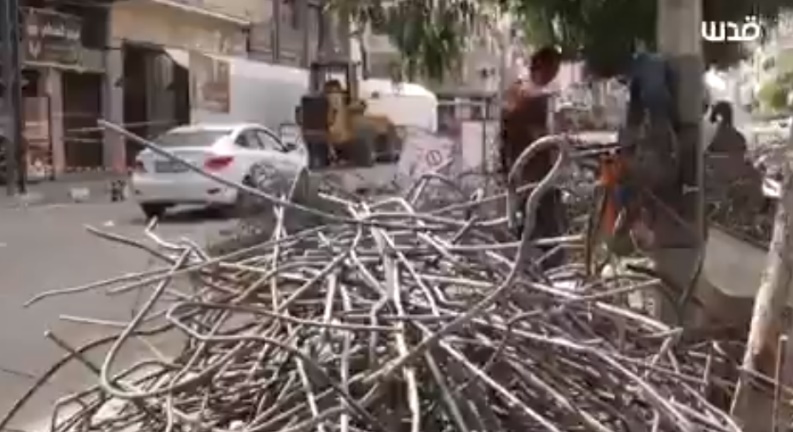 Palestinian workers extract steel pipes from the rubble of the al-Johara Building in Gaza City, hit by the IDF during Operation Guardian of the Walls (QudsN Twitter account, October 17, 2021). 