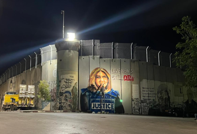 A picture of Shireen Abu Akleh pained on the border security fence in Bethlehem for Biden's expected visit to the city (Wafa, July 6, 2022).