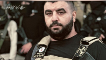 al-Ghoul wearing a bulletproof vest with Jenin Battalion and al-Bahaa Force tags on the straps. 