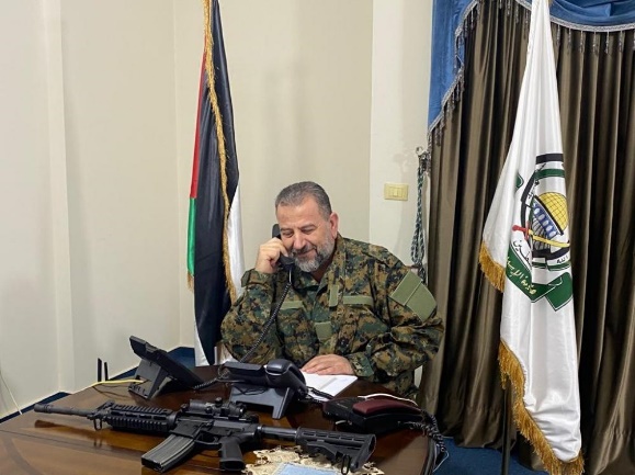 Photos of Saleh al-Arouri in uniform with an M-16 rifle on his desk, published in response to the Israeli prime minister's threat (Shehab, August 27, 2023)