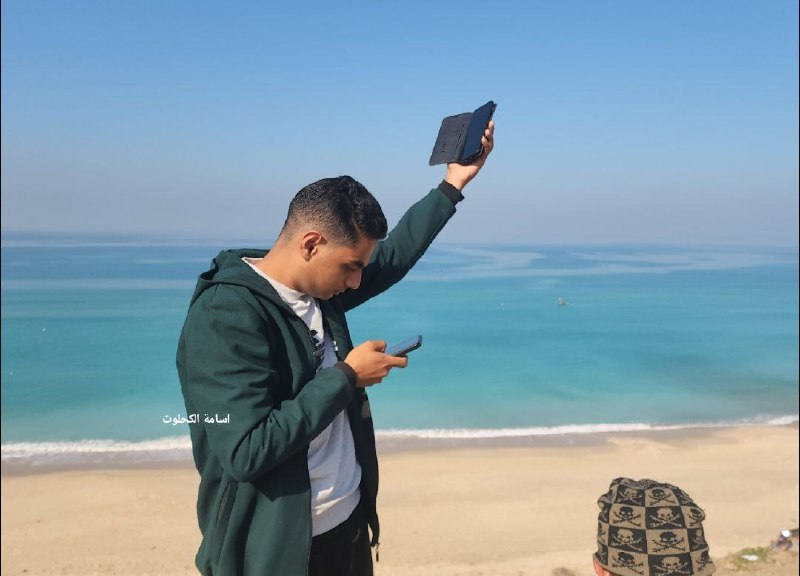 Due to communication and reception problems in the Gaza Strip, displaced persons in Deir al-Balah look for good reception areas at the beach for their mobile phones (QudsN X account, January 22, 2024) 