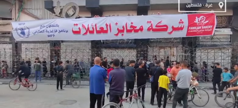 Residents wait in line to buy pita at a bakery in Gaza City which recently reopened (Wafa YouTube channel, April 20, 2024)