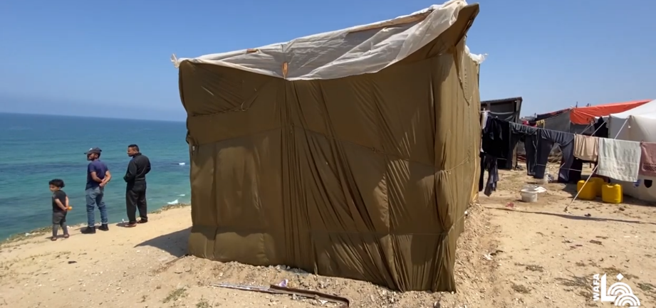 A displaced Gazan staying in Deir al-Balah built a tent for his family from the airlift parachutes which dropped aid in the Gaza Strip (Wafa YouTube channel, April 17, 2024)