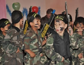 Children wearing uniforms and carrying wooden rifles march in a Palestinian Islamic Jihad kindergarten's graduation party. 